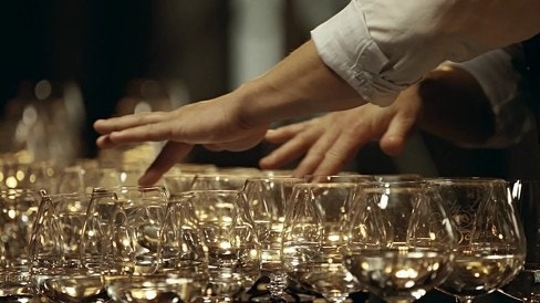 유리잔 가장자리를 문질러 소리를 내며 공진 특성을 체감하는 실험 장면