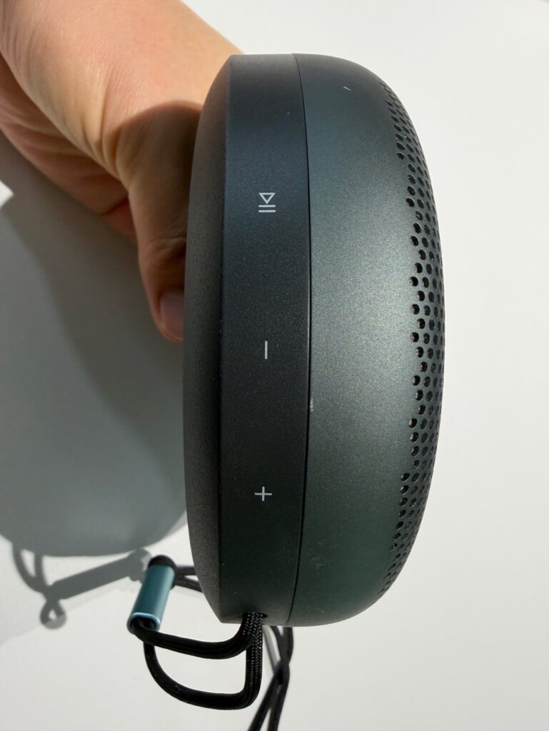 베오사운드 A1 2세대 측면 조작 버튼 클로즈업(재생·볼륨 +/−)