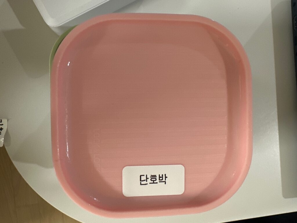 이유식 통에 라벨을 붙인 모습 님봇 D110 라벨프린터 사용 예시