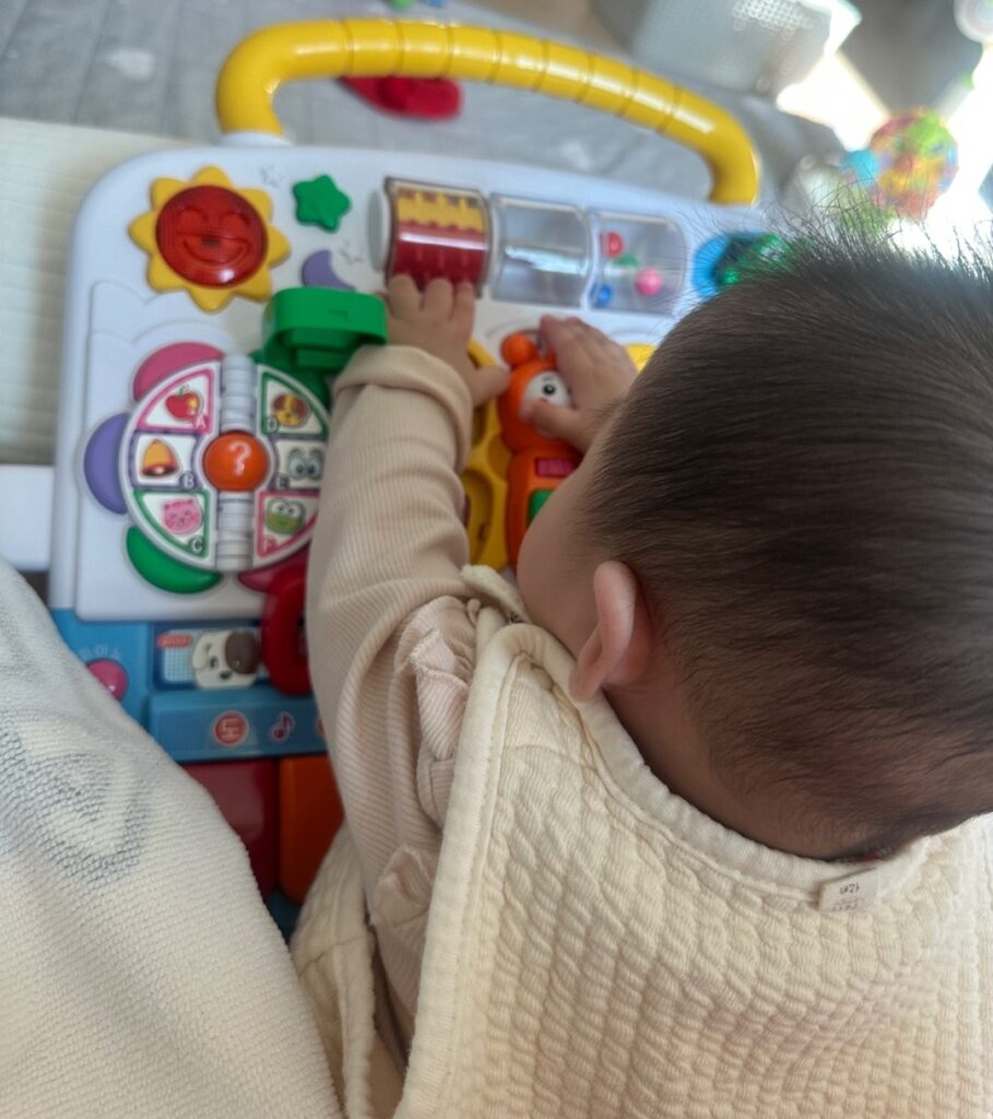 코니스 에듀테이블 상단 조작부를 만지며 반응을 즐기는 아기